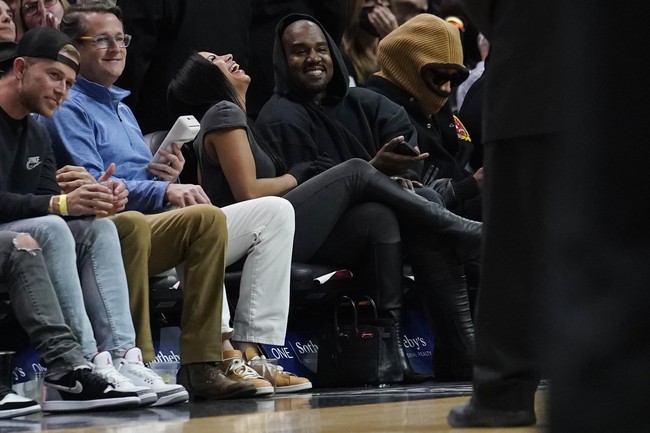 Duduk di barisan terdepan, keduanya pun sudah tak sungkan untuk menunjukkan kemesraan mereka di hadapan publik. Chaney Jones tampak begitu bahagia berada di dekat Kanye West. (Foto: AP/Marta Lavandier)