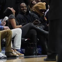 Duduk di barisan terdepan, keduanya pun sudah tak sungkan untuk menunjukkan kemesraan mereka di hadapan publik. Chaney Jones tampak begitu bahagia berada di dekat Kanye West. (Foto: AP/Marta Lavandier)