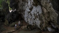 Sejumlah pengunjung berjalan memasuki gua purbakala di kawasan wisata prasejarah Leang-Leang, Maros, Sulawesi Selatan, Kamis (17/3/2022).