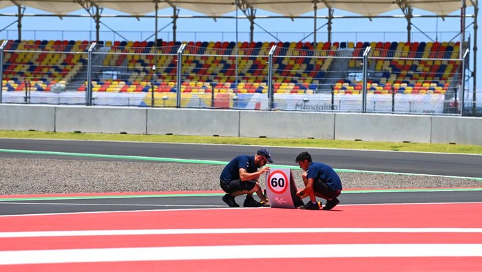 Marshall memasang tanda informasi tikungan di Pertamina Mandalika International Street Circuit, Lombok Tengah, NTB, Kamis (17/3/2022). Ajang balapan MotoGP seri kedua 2022 bertajuk Pertamina Grand Prix of Indonesia akan berlangsung pada 18-20 Maret 2022. ANTARA FOTO/Andika Wahyu.