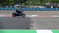 Petugas mengendarai sepeda motor di batas aspal baru (kiri) dan aspal lama (kanan) Pertamina Mandalika International Street Circuit, di Lombok Tengah, NTB, Kamis (17/3/2022).