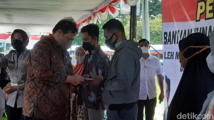 Menko Bidang Perekonomian Airlangga Hartarto membagikan bantuan ke pedagang di sentra UMKM Maguwoharjo, Sleman, Kamis (17/3/2022).