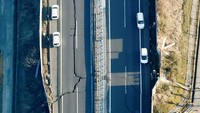 Gempa juga menyebabkan ruas jalan yang berada di Shiroishi, Prefektur Miyagi, Jepang, retak. Kondisi itu membuat sejumlah kendaraan berhenti melintas. Kyodo/via REUTERS.
