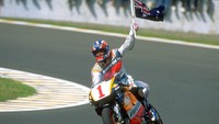 Michael Doohan dari Australia memegang bendera Nasional Australia di atas motor Honda setelah memenangkan balapan 500cc dari Grand Prix Indonesia di sirkuit Sentul. (Getty Images/Michael Cooper)