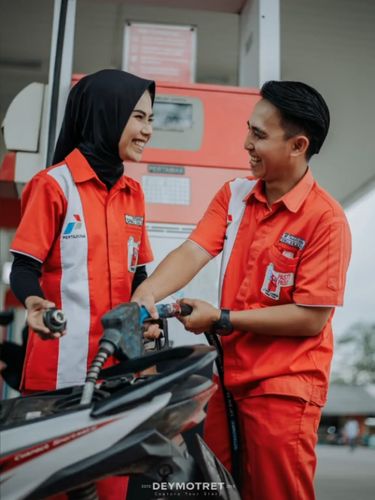 Pasangan yang mengadakan sesi foto prewedding di SPBU.