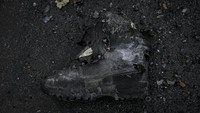Sepatu militer tergeletak di samping tank Rusia yang hancur di Irpin. (AP Photo/Vadim Ghirda).