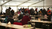 Pengungsi dari Ukraina menunggu di tenda untuk transportasi lebih lanjut setelah mereka tiba di stasiun kereta api utama di Berlin, Jerman, Rabu, (16/3/2022). Perang Ukraina telah mengubah ruang bawah tanah stasiun kereta api utama kaca dan baja Berlin menjadi kota pengungsi yang luas. (AP/Markus Schreiber)