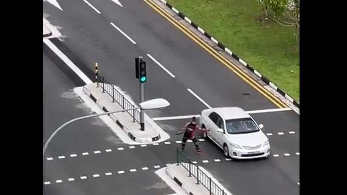 Pria menebas pedang ke mobil yang melintas
