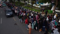 Foto udara antrean warga hingga di badan jalan untuk mendapatkan minyak goreng murah dalam kemasan di pasar murah di Kantor Dinas Perindustrian dan Perdagangan Provinsi Sulawesi Tenggara, Kendari, Sulawesi Tenggara, Kamis (17/3/2022).