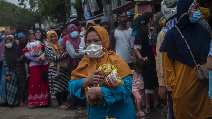 Warga membawa minyak goreng kemasan yang dibelinya di Rangkasbitung, Lebak Banten, Jumat (18/3/2022). Warga di daerah tersebut berburu minyak goreng kemasan dari agen yang masih menyediakan stok minyak goreng subsidi dengan harga jual Rp14 ribu per liter. ANTARA FOTO/Muhammad Bagus Khoirunas/rwa.