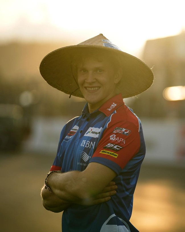 Begini gaya melokal Gabriel Rodrigo menjelang balapan di Sirkuit Mandalika. Topi caping ternyata cocok dipadukan dengan baju balapnya. Foto: Instagram