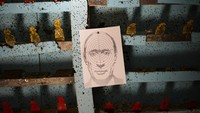 Gambar-gambar lain menangkap perlawanan gigih negara itu terhadap invasi Rusia. Dalam satu, target kertas bertuliskan wajah Presiden Rusia Vladimir Putin telah ditempelkan ke dinding jangkauan target. Di tempat lain, dua prajurit Ukraina, satu dengan rokok menggantung di mulutnya dan tatapan waspada di matanya, menjaga posisi mereka di dekat Brovary, sebuah kota di utara ibu kota Kyiv. (AP Photo/Bernat Armangue).