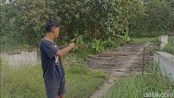 Warga enunjukkan jembatan rusak di dlam Hutan Kramat Grobogan, Jumat (18/3/2022).