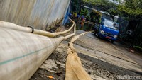 Selang air terlihat digunakan untuk memompa banjir di kawasan tersebut. 