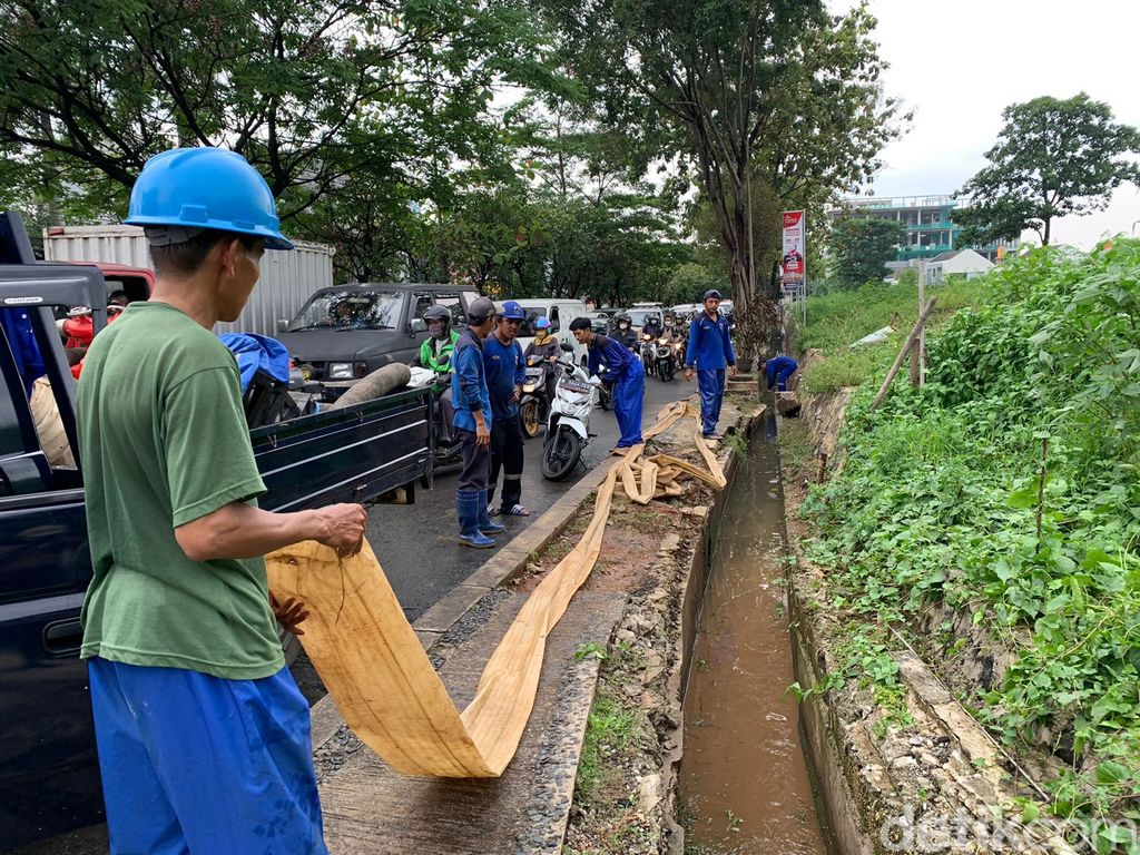 Pasukan biru tangani genangan di sumur resapan Jl Karang Tengah Raya, Lebak Bulus, Jaksel, 18 Maret 2022, sore. (Mulia Budi/detikcom)