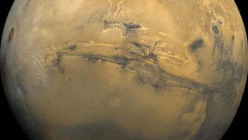 Sejumlah robot penjelajah memang sudah menangkap foto-foto terbaru Mars, namun kebanyakan diambil di permukaan daratan. Foto yang satu ini adalah hasil jepretan tahun 1980, dan menampilkan Mars secara bulat utuh. Foto ini diambil oleh wahana pengorbit Viking 1. Celah di tengah itu adalah Valles Marineris, sebuah ngarai besar di sepanjang ekuator planet yang termasuk yang terbesar di Tata Surya kita. Foto: NASA/USGS