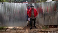 Tampak rumah ini masih ditutupi oleh seng di bagian depannya. Terlihat masih ada beberapa pekerja proyek yang hilir mudik ke luar masuk ke dalam rumah Indra Kenz.  