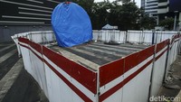 Tugu itu masih tertutup terpal warna biru. Di sekelilingnya juga ditutup dengan pembatas seng.