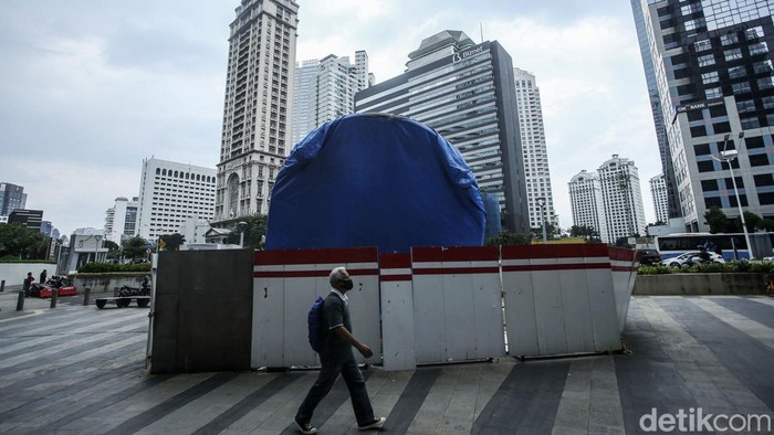 Tugu Sepeda Sudirman Masih Tertutup Rapat Warga melintas di sekitar Tugu Sepeda di Jalan Sudirman, Jakarta, Jumat (18/3/2022). Tugu yang dibangun dengan anggaran Rp 800 juta itu tak kunjung dibuka.