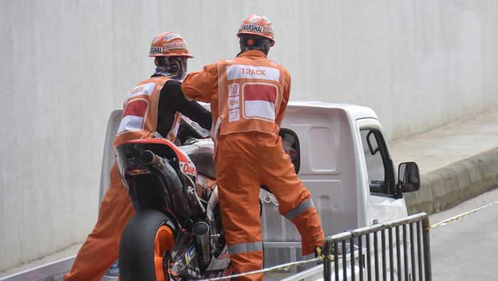 Pembalap Repsol Honda Team Marc Marquez membonceng marshal usai terjatuh saat kualifikasi MotoGP di Pertamina Mandalika International Street Circuit, Praya, Lombok Tengah, NTB, Sabtu (19/3/2022). Pembalap Monster Energy Yamaha Fabio Quartararo merebut pole position dan berhak start terdepan pada balapan MotoGP seri kedua 2022 pada Minggu (20/3) setelah mencatatkan waktu tercepat 1 menit 31,067 detik.ANTARA FOTO/Ahmad Subaidi/rwa.