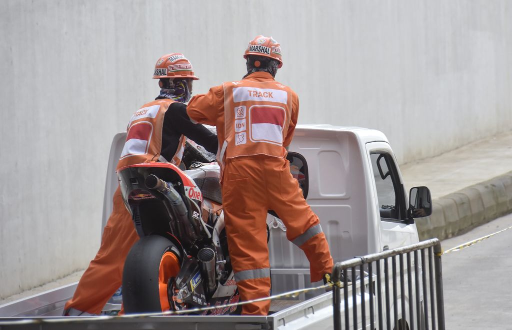 Pembalap Repsol Honda Team Marc Marquez membonceng marshal usai terjatuh saat kualifikasi MotoGP di Pertamina Mandalika International Street Circuit, Praya, Lombok Tengah, NTB, Sabtu (19/3/2022). Pembalap Monster Energy Yamaha Fabio Quartararo merebut pole position dan berhak start terdepan pada balapan MotoGP seri kedua 2022 pada Minggu (20/3) setelah mencatatkan waktu tercepat 1 menit 31,067 detik.ANTARA FOTO/Ahmad Subaidi/rwa.