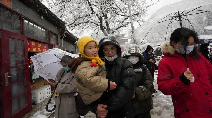Keindahan Kota Terlarang China di Tengah Salju A figurine of Bing Dwen Dwen, the 2022 Winter Olympics mascot is placed on a gate by visitors to the Forbidden City as it snows on Friday, March 18, 2022, in Beijing. (AP Photo/Ng Han Guan)
