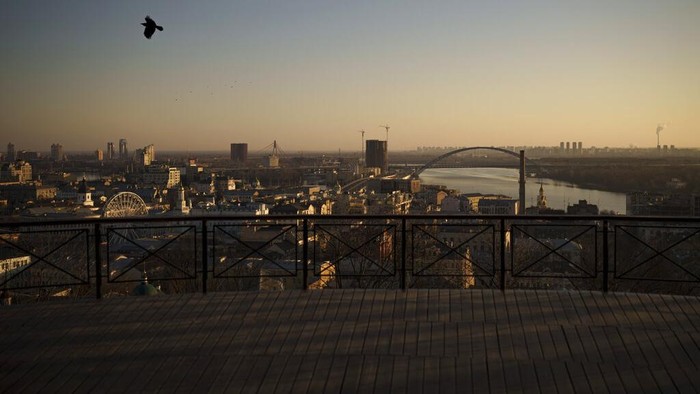 A bird flies as the sun rises during curfew in Kyiv, Ukraine, Friday, March 18, 2022. (AP Photo/Felipe Dana)