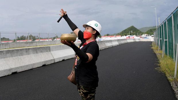 Pawang Hujan Gelar Ritual Usir Cuaca Buruk di Sirkuit Mandalika A woman conducts a traditional ritual for good weather during a practice session for the Indonesian Grand Prix MotoGP at the Mandalika International Circuit at Kuta Mandalika in Central Lombok on March 18, 2022. (Photo by SONNY TUMBELAKA / AFP)