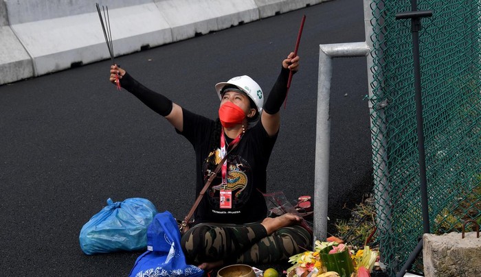 A woman conducts a traditional ritual for good weather during a practice session for the Indonesian Grand Prix MotoGP at the Mandalika International Circuit at Kuta Mandalika in Central Lombok on March 18, 2022. (Photo by SONNY TUMBELAKA / AFP)