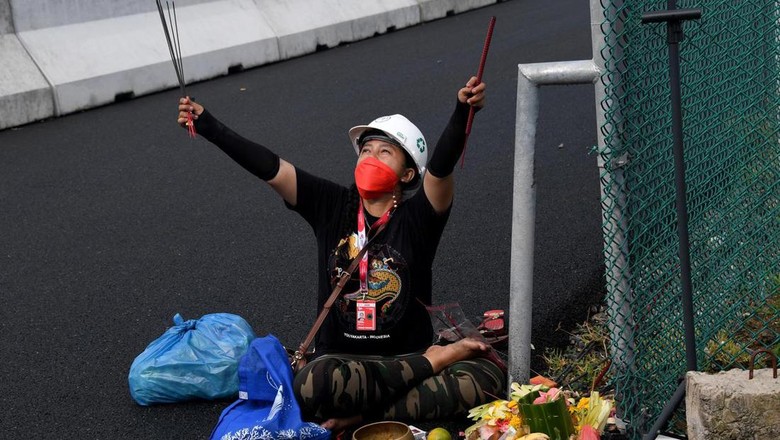 Pawang Hujan Gelar Ritual Usir Cuaca Buruk di Sirkuit Mandalika A woman conducts a traditional ritual for good weather during a practice session for the Indonesian Grand Prix MotoGP at the Mandalika International Circuit at Kuta Mandalika in Central Lombok on March 18, 2022. (Photo by SONNY TUMBELAKA / AFP)