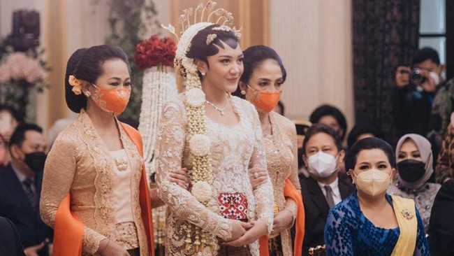 Akad nikah digelar dalam nuansa Jawa yang kental. Kedua mempelai tampil serasi dengan busana pengantin adat Solo. Kebaya off white dengan detail Swarovski dan payet berwarna emas, silver dan krem, dengan sentuhan batik jumputan bernuansa merah sukses memancarkan pesona Putri. Samuel Rustandi/Morden.co