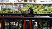 Seorang pengunjung JPO Pinisi asyik berswafoto.
