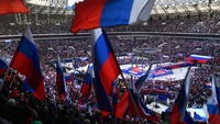 Puluhan ribu warga Rusia di Moskow mengibarkan bendera kebangsaan mereka sebagai simbol kejayan negara dalam peringatan delapan tahun perebutan Krimea oleh Kremlin. AP/Evgeny Biyatov