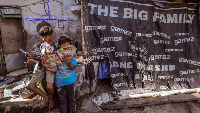 Dua anak membaca buku yang dipinjam dari perpustakaan keliling di Pabuaran, Cibinong, Kabupaten Bogor, Jawa Barat, Minggu (20/3/2022). Perpustakaan keliling yang digelar oleh komunitas Cibinong Society itersebut untuk menambah ilmu pengetahuan serta meningkatkan minat baca terhadap anak di usia dini di kawasan perkampungan. ANTARA FOTO/Yulius Satria Wijaya/YU