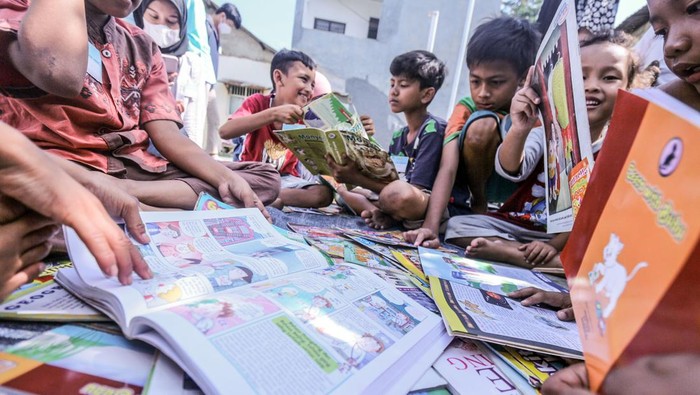 Dua anak membaca buku yang dipinjam dari perpustakaan keliling di Pabuaran, Cibinong, Kabupaten Bogor, Jawa Barat, Minggu (20/3/2022). Perpustakaan keliling yang digelar oleh komunitas Cibinong Society itersebut untuk menambah ilmu pengetahuan serta meningkatkan minat baca terhadap anak di usia dini di kawasan perkampungan. ANTARA FOTO/Yulius Satria Wijaya/YU