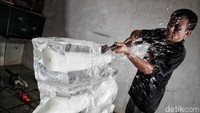 Giri Subagio menunjukkan cara ia memahat bongkahan es menjadi karya seni dibantu oleh keponakannya, Gilang.