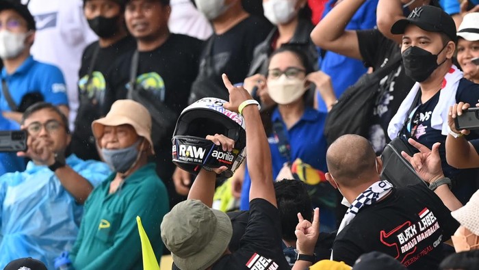 Seorang penonton berhasil menangkap helm yang dilemparkan pembalap Aprilia Racing Aleix Espargaro seusai balapan MotoGP seri Pertamina Grand Prix of Indonesia di Pertamina Mandalika International Street Circuit, Lombok Tengah, NTB, Minggu (20/3/2022). Aleix Espargaro memenuhi janjinya untuk melemparkan helm kepada penonton usai berhasil meraih jumlah pengikut di Instagramnya sebanyak satu juta orang sebelum balapan MotoGP pada hari Minggu (23/3). ANTARA FOTO/Andika Wahyu/foc.