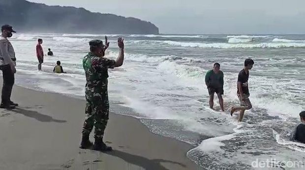 Suasana di Pantai Parangtritis, tampak petugas dari TNI-Polri tengah mengawasi wisatawan yang abai terhadap prokes, Minggu (20/3/2022).