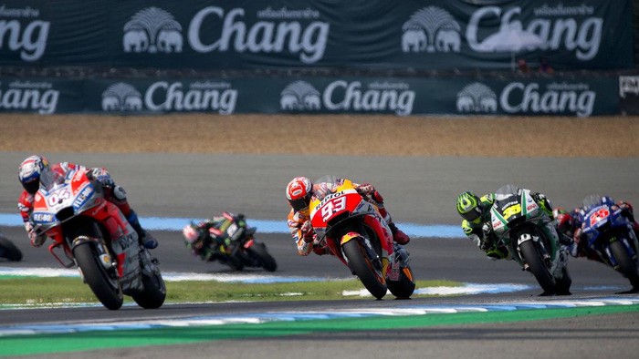 Spains rider Marc Marquez of the Repsol Honda Team, center, and Italys rider Andrea Dovizioso of the Ducati Team, left, ride with a pack of competing riders during Thailands inaugural MotoGP Grand Prix at the Chang International Circuit in Buriram, Thailand, Sunday, Oct. 7, 2018. (AP Photo/Gemunu Amarasinghe)