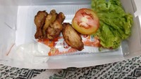 Niat pesan sayap ayam layaknya di restoran ternama, netizen ini justru harus menelan pahit. Penggunaan kotak kemasan yang kebesaran membuat sayap ayamnya terlihat semakin mini. Foto: Instagram/humorsantuy