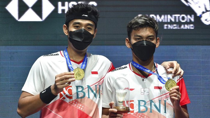 Debut Memukau Bagas/Fikri yang Langsung Juara di All England 2022 Indonesia's Muhammad Shohibul Fikri, right, and Bagas Maulana celebrate with their gold medals following their victory over their compatriots Mohammad Ahsan and Hendra Setiawan in their men's doubles final match at the All England Open Badminton Championships in Birmingham, England, Sunday, March 20, 2022. (AP Photo/Rui Vieira)
