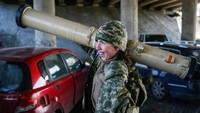 Tetiana Chornovol tampak membawa rudal anti-tank saat bersiaga di posisi garis depan, di tengah invasi Rusia ke Ukraina di wilayah Kyiv, Minggu (20/3/2022).