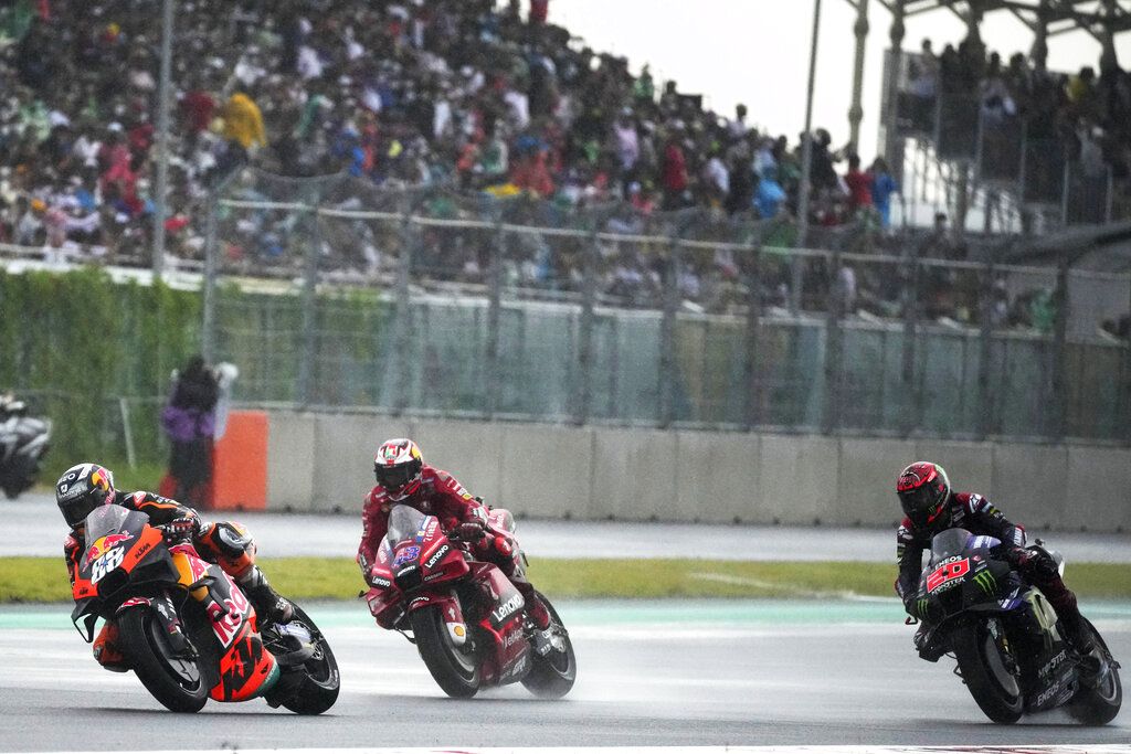 Portugal's Miguel Aliveira of Red Bull KTM Factory Racing, left, leads Australian rider Jack Miller of Ducati Lenovo team, center, French rider Fabio Quartararo of Monster Energy Yamaha MotoGP, right, during Moto GP Pertamina Grand Prix of Indonesia at the Pertamina Mandalika Circuit in Mandalika, Lombok Island, Indonesia, Sunday, March 20, 2022.(AP Photo/Achmad Ibrahim)