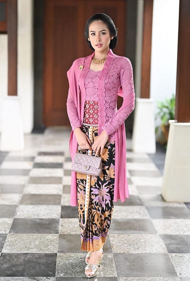 Ia memilih kebaya Kutubaru dengan padanan kain Batik serta selendang yang menambah kesan anggun. Kebaya lace warna pink ini merupakan rancangan Didiet Maulana. Foto: Instagram/@maudyayunda