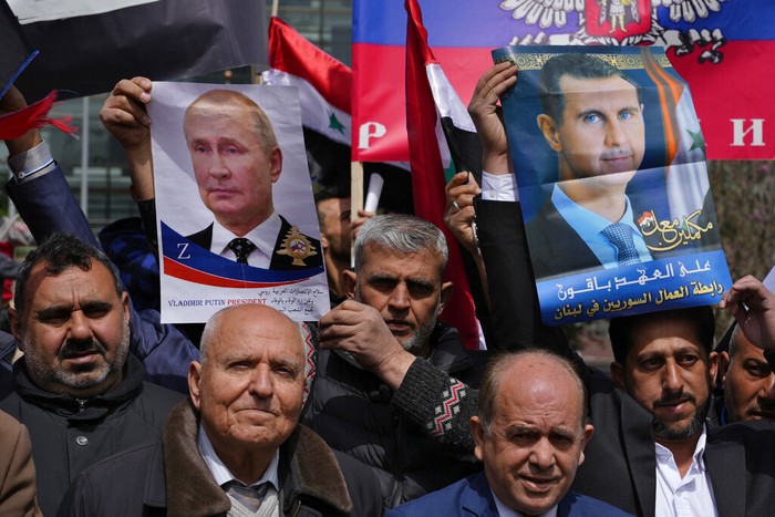 Pendukung Vladimir Putin Para pengunjukrasa membawa foto Presiden Vladimir Putin saat berdemo di di depan markas besar PBB di Beirut, Lebanon, Minggu, (20/3/2022). Mereka mendukung Putin memborbardir Ukraina.