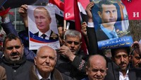 Selain foto Putin, pendemo juga membawa foto Presiden Suriah, Bashar Assad.