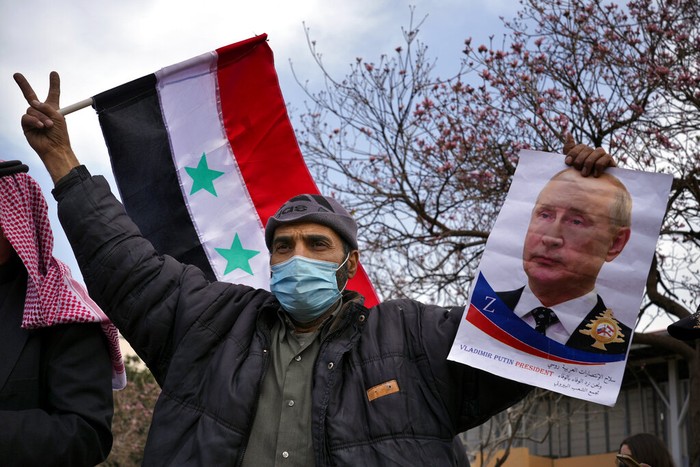 Pendukung Vladimir Putin Para pengunjukrasa membawa foto Presiden Vladimir Putin saat berdemo di di depan markas besar PBB di Beirut, Lebanon, Minggu, (20/3/2022). Mereka mendukung Putin memborbardir Ukraina.
