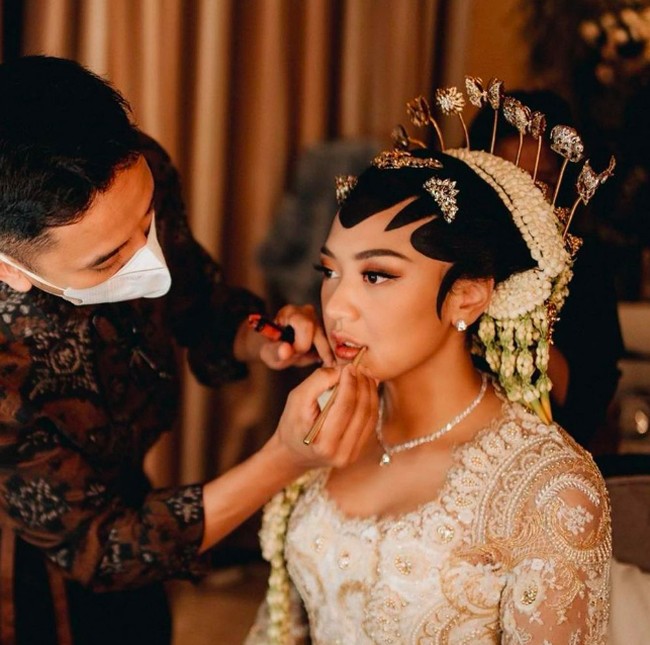 Keesokan harinya, Minggu (20/3/2022) dilanjutkan dengan acara akad nikah. Putri Tanjung menggunakan riasan yang lebih glamour dibanding beberapa acara sebelumnya. Dia pun tampil dengan paes serta sanggul. Foto: dok. Morden.co