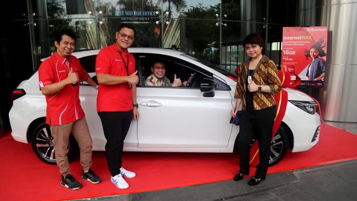Rejeki Nomplok untuk Dosen Surabaya General Manager Consumer Sales Telkomsel Jawa Timur, Mulyadi Indra (dua dari kiri) didampingi Manager Branch Surabaya, Andri Trisnanto menyerahkan hadiah Telkomsel Poin kepada pelanggan asal Surabaya, Lexi Pranata yang merupakan dosen di salah satu kampus di Surabaya.