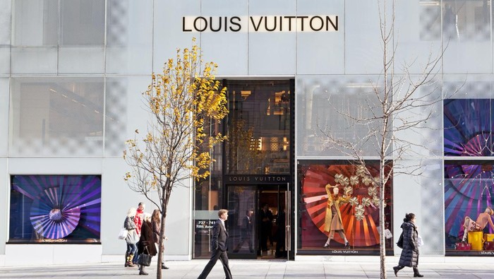 New York City, USA - December 6, 2012: People walking on the sidewalk in front of the Louis Vuitton store at Fifth avenue.
